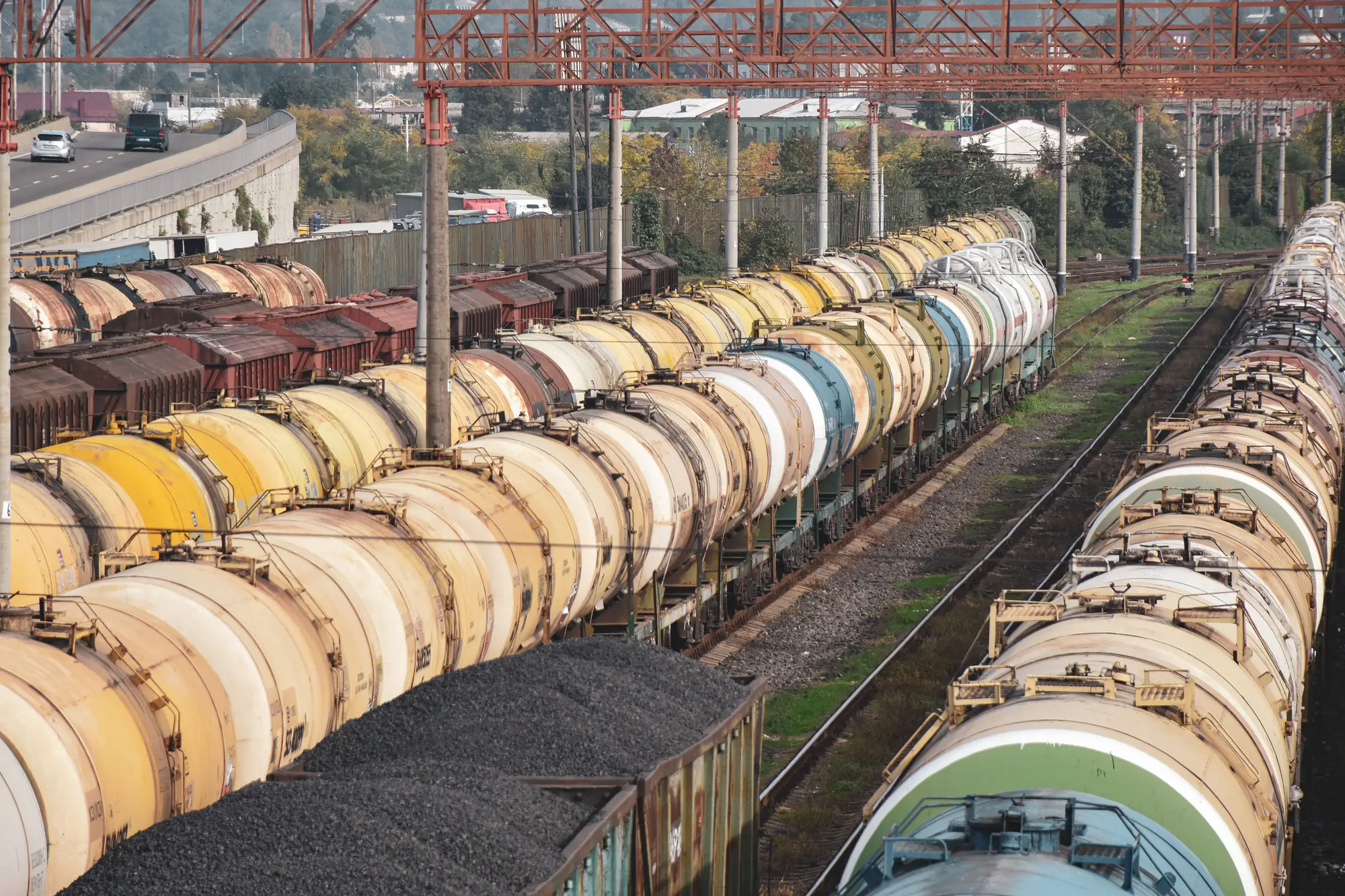 Long rakes of tank wagons standing side by side on parallel sidings, seen from a footbridge